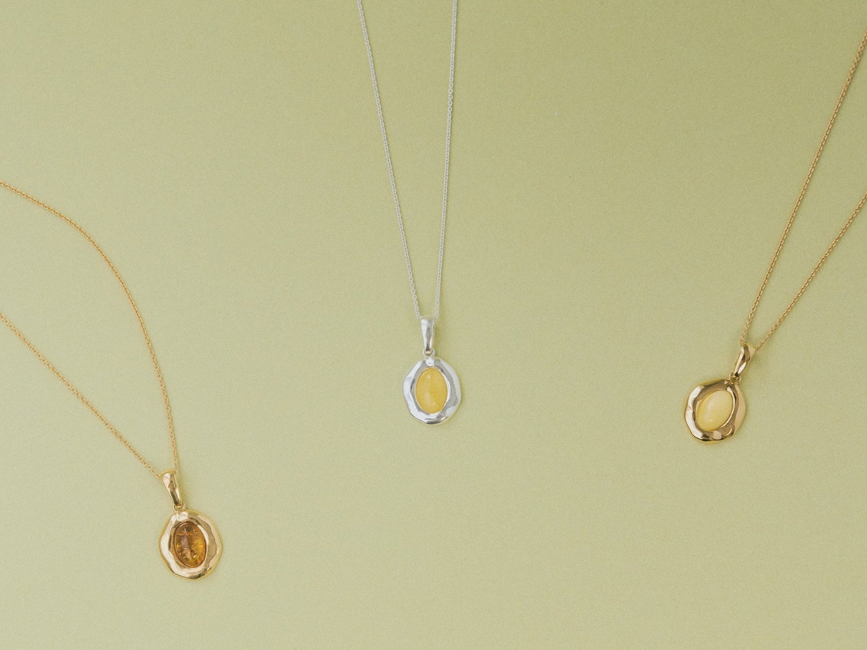 Three amber pendants on a light green background