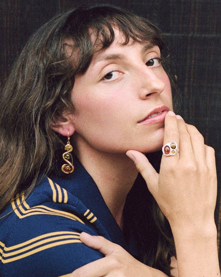 Woman wearing a blue and yellow striped shirt against a dark wooden background